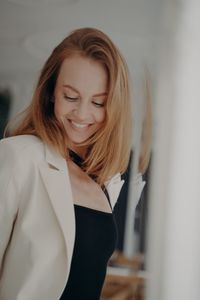 Portrait of young woman standing against wall