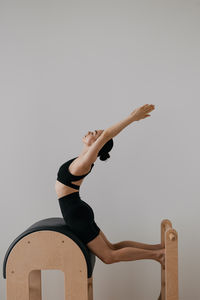 Low angle view of woman exercising against white background