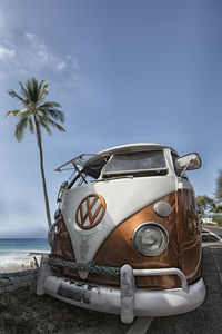 Vintage car on beach against sky