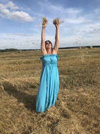 Full length of smiling young woman on field