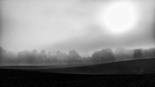 Scenic view of field against sky during foggy weather