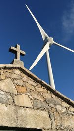 Low angle view of windmill against clear blue sky