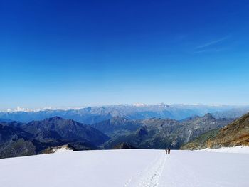 Scenic view of snowcapped mountain against blue sky