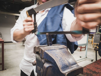 Midsection of man working at workshop