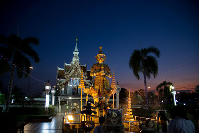 Illuminated buildings against sky at night