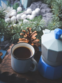 Coffee in cups on wooden board over christmas winter background