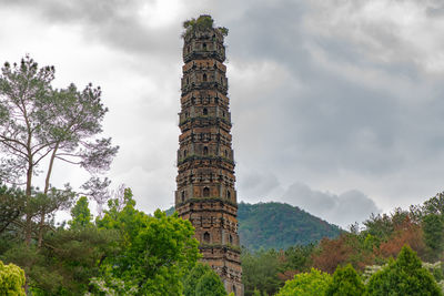 Low angle view of tower against cloudy sky