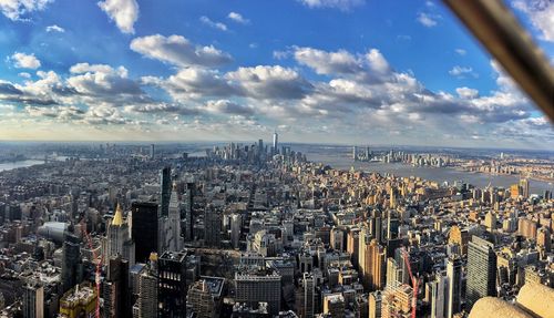 High angle view of city buildings against cloudy sky