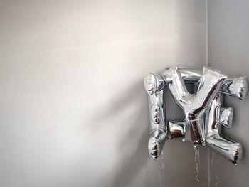 Silver balloons against wall