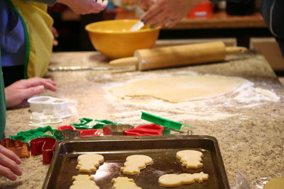 Cropped hands making cookies in kitchen at home