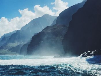 Scenic view of sea and mountains against sky