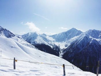 Scenic view of snowcapped mountains against cloudy sky