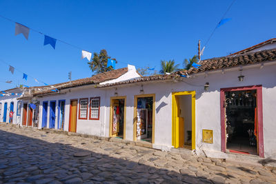 Multi colored houses by street against blue sky