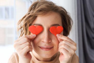 Close-up portrait of woman holding heart