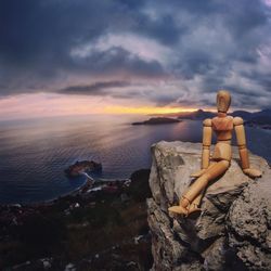 Scenic view of rocks on beach against sky during sunset