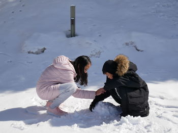 Rear view of women on snow covered land