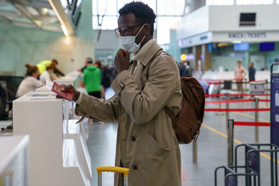 Man wearing mask while standing at airport