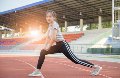 Young woman exercising on sports track