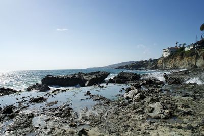 Scenic view of rocks on beach against sky