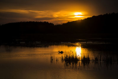 Scenic view of lake against orange sky