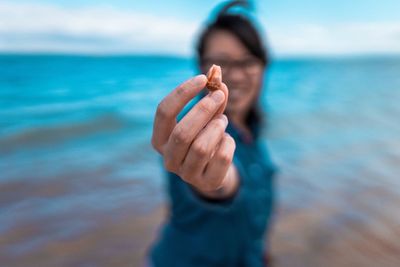 Portrait of man holding leaf at beach