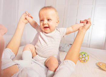 Portrait of cute baby boy lying on bed at home