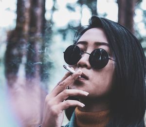 Portrait of young woman holding sunglasses