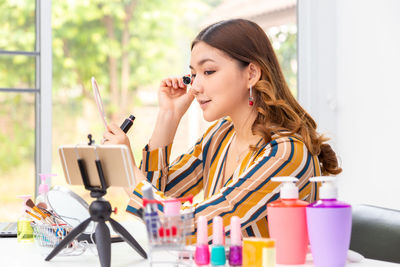 Woman looking away while sitting on table