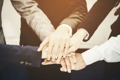 Cropped image of business people stacking hands