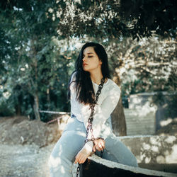 Portrait of young woman sitting on field