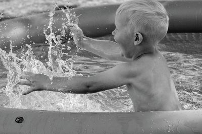 Full length of shirtless boy in wading pool