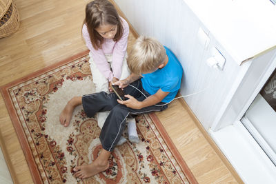 High angle view of girl sitting on floor at home