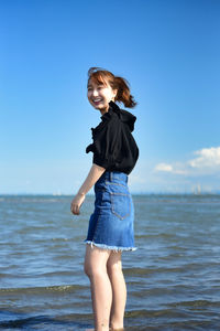 Side view of young woman standing in sea