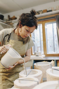 Potter pouring clay in ceramics at workshop