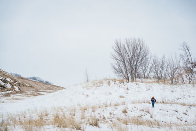 Man on snow covered field against sky