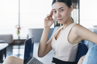 Portrait of young woman using mobile phone