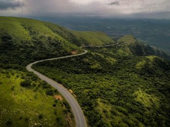High angle view of road amidst green landscape against sky
