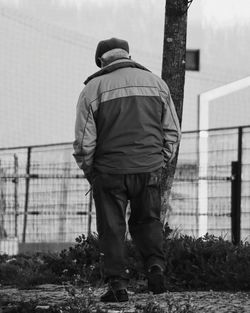 Rear view of man standing against built structure