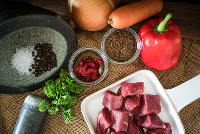 Close-up of meat with ingredients on burlap