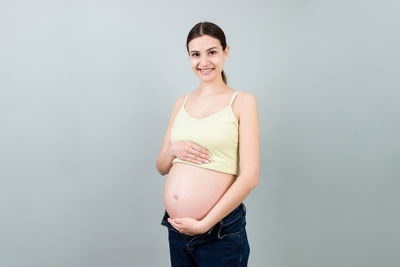 Portrait of a smiling young woman against white background