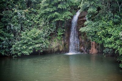 Scenic view of waterfall against sky