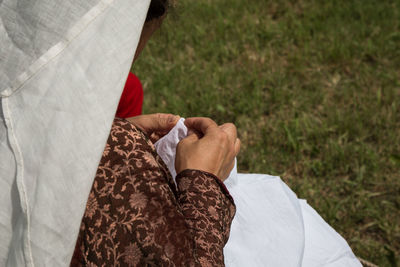 High angle midsection of woman sewing textile