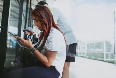 Side view of young woman standing in city