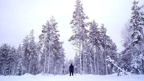 People on snow covered field against sky