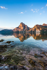 Scenic view of lake and mountains against blue sky