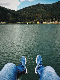 Low section of man standing by lake