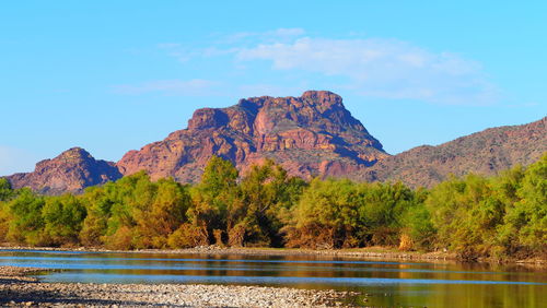 Scenic view of lake and mountains against blue sky