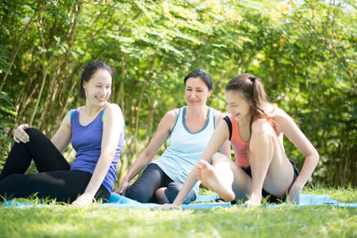 Yoga instructor doing yoga with women at park