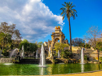 Fountain in front of building against sky