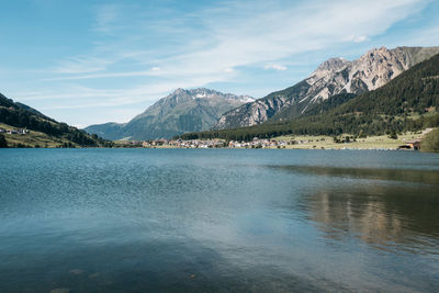 Scenic view of lake by mountains against sky